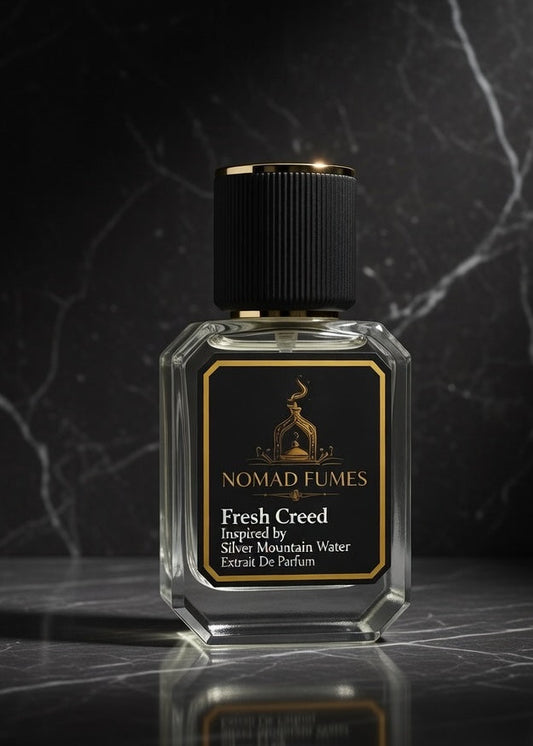 Perfume bottle labeled 'Nomad Fumes' on a dark marble surface with a dark background
