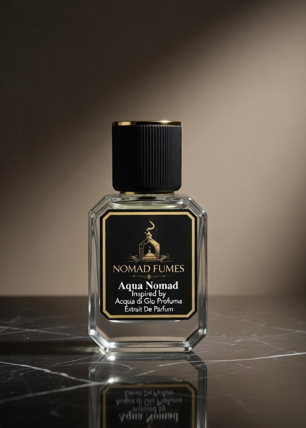 Perfume bottle labeled 'Aqua Nomad' by Nomad Fumes on a dark marble surface with a spotlight effect.